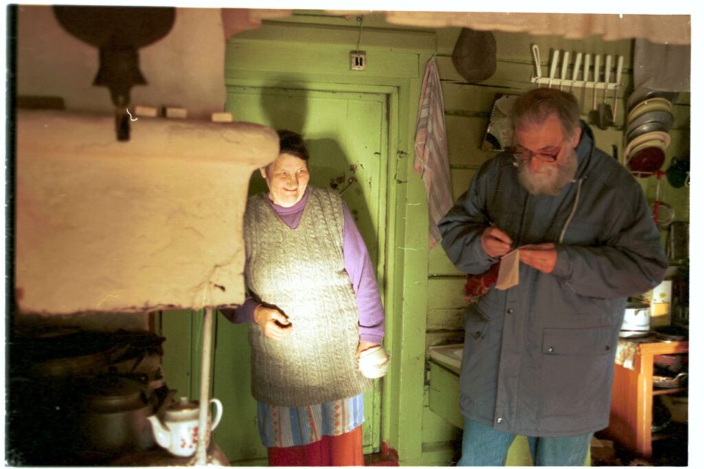 Mies (kirjoittamassa) ja nainen pirtissä